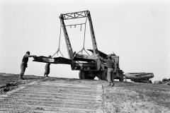 A Brockway bridge erector truck of 17thAEB, lowers treadway bridge sections down the bank of the Rhine.