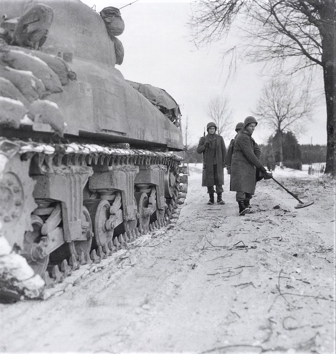 January 16, 1945, Road to Houffalize, Belgium. Engineers of the 17th Armored Engineer Battalion sweep for mines, it is cleary a staged situation. Photo from the 165th signal company, by the name of Ellet. (Source: Neelys Forgotten Archives - 1)